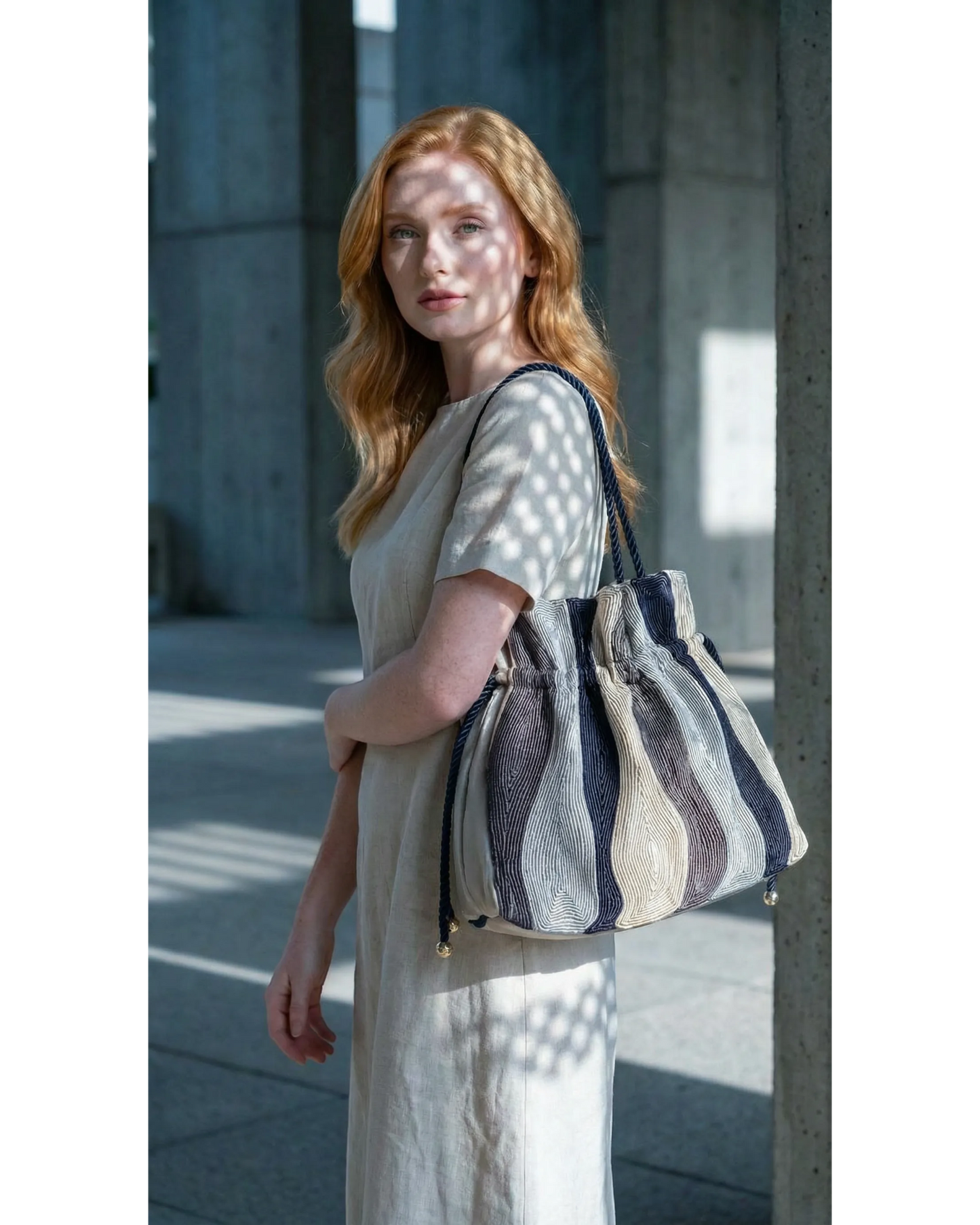 Farah Daylac embroidered pouch bag with drawstring closure, featuring a striped pattern in navy, beige, and white.