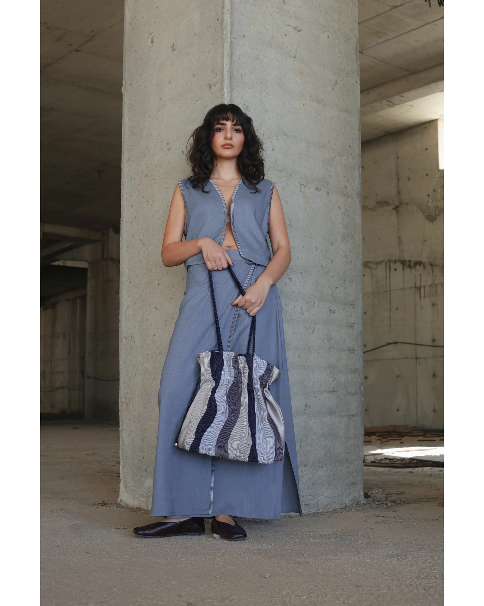 Farah Daylac cream, grey, and navy striped pouch bag with rope handle and gold hardware.